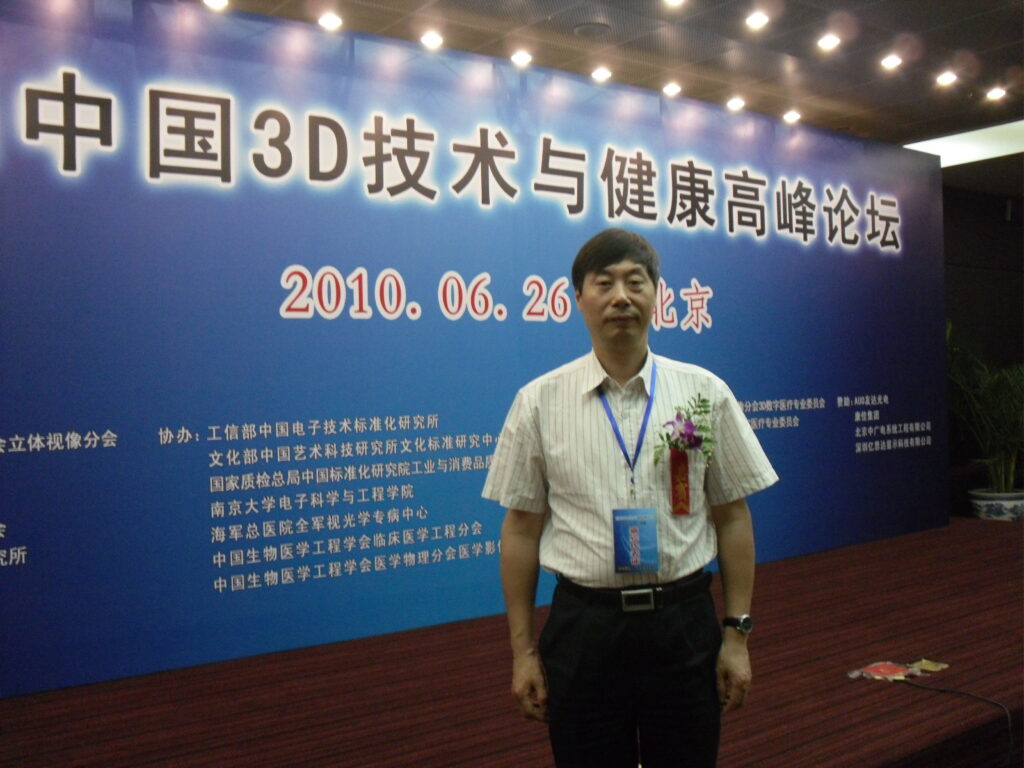 用户提供的活动留影,人物站在“中国3D技术与健康高峰论坛”背景板前,画面可见“2010.06.26 · 北京”
