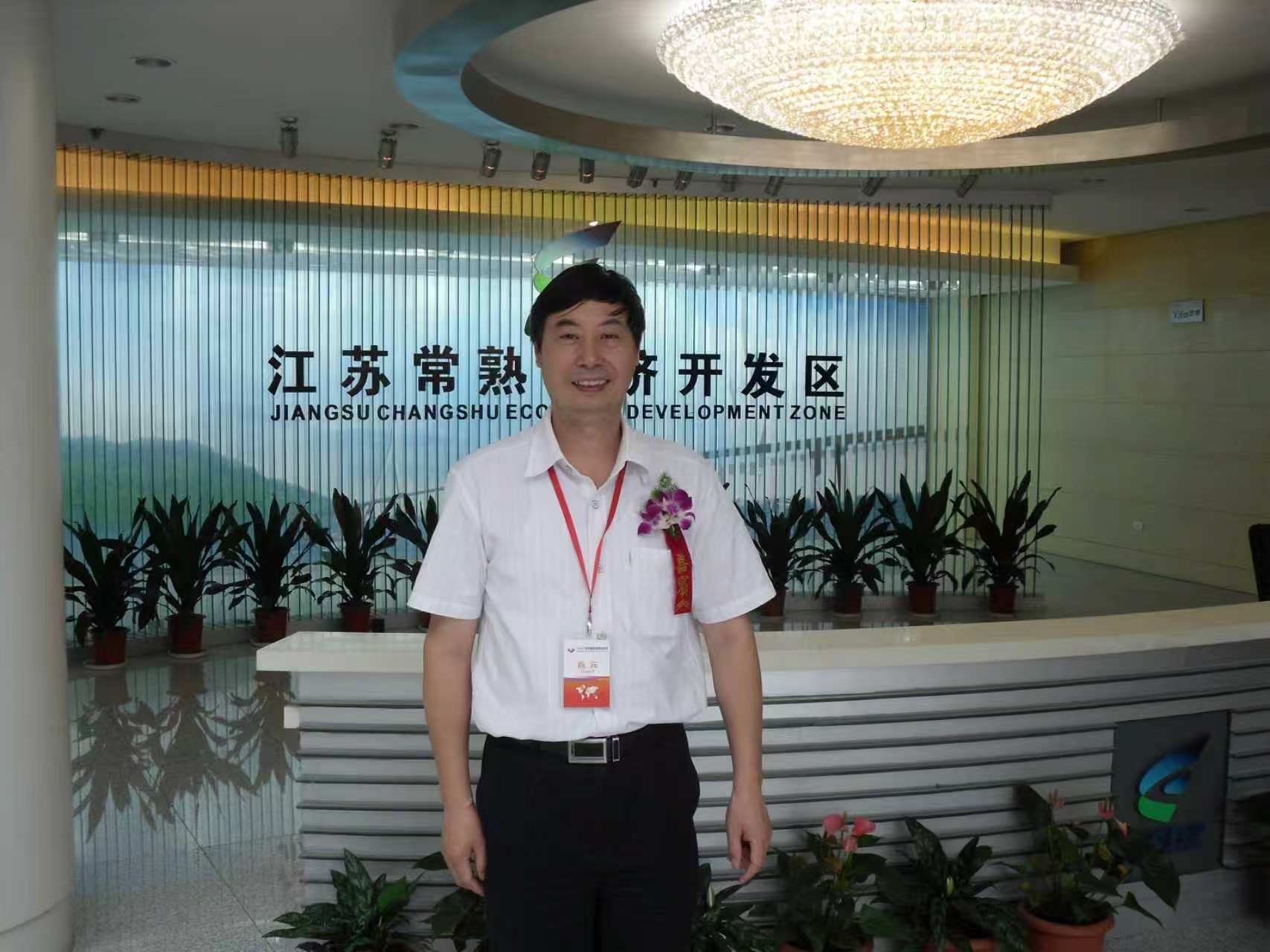 用户提供的活动留影，人物站在“江苏常熟经济开发区”标识前